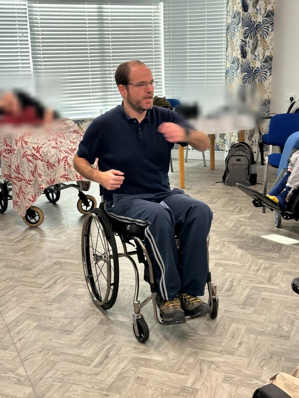 Mat Richards leading a chair-based exercise to music session in a care home lounge